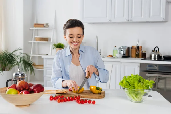 Fröhliche Frau bereitet Frühstück aus frischem Gemüse in der Küche zu — Stockfoto