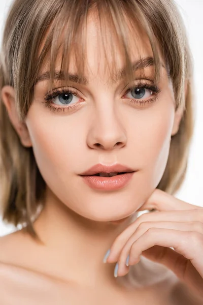 Close up view of young woman with bangs and blue eyes looking at camera isolated on white — Photo de stock