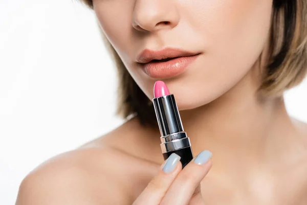 Cropped view of young woman holding pink lipstick isolated on white — Stockfoto