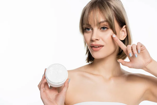 Bella giovane donna con frangia contenitore con crema viso isolato su bianco — Foto stock