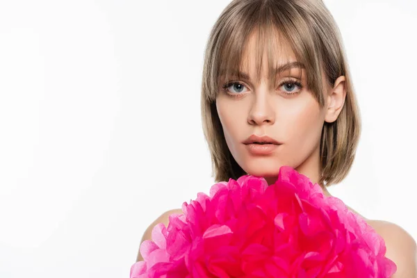 Mujer joven con flequillo cerca flor decorativa rosa aislado en blanco - foto de stock