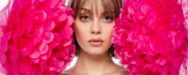 Blonde young woman looking at camera near bright pink flowers isolated on white, banner — Photo de stock