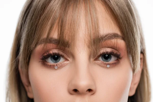 Cropped view of young woman with bangs and shiny rhinestones under blue eyes isolated on white — Stock Photo