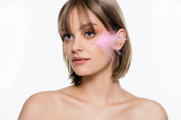 Young woman with blue eyes and pink feather on face isolated on white - foto de stock