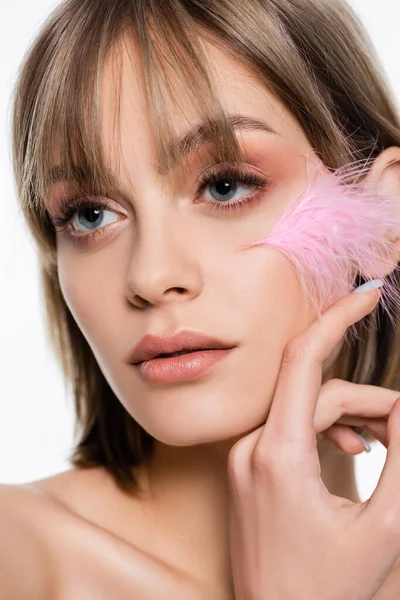 Sensual young woman with blue eyes and pink feather on face isolated on white — Stockfoto