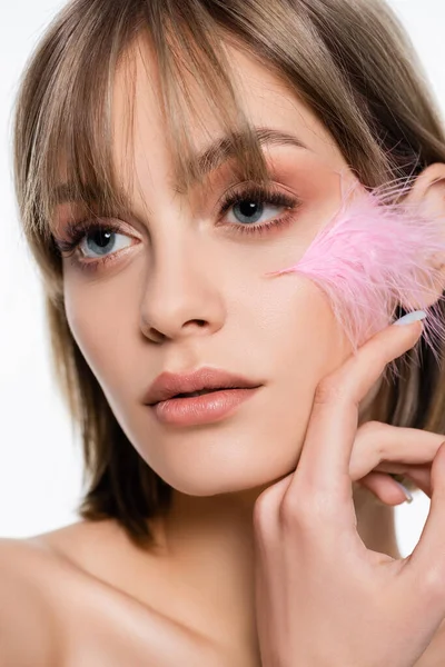 Sensual young woman with blue eyes and pink feather on face isolated on white — Foto stock