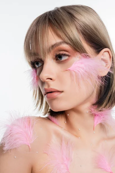 Femme avec des éléments décoratifs et des plumes sur le visage et le corps isolé sur blanc — Photo de stock