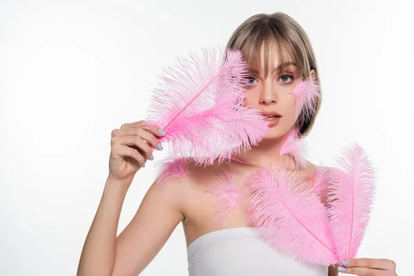 Mulher bonita com contas decorativas no pescoço segurando penas rosa isolado no branco — Fotografia de Stock