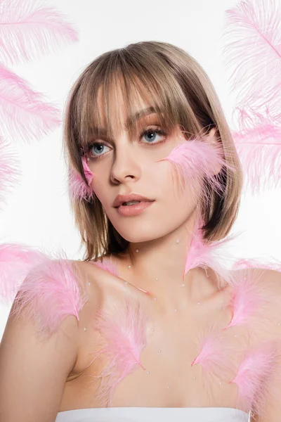 Young woman with decorative beads on neck near pink feathers isolated on white - foto de stock