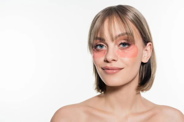 Mujer joven feliz con parches de hidrogel en los ojos aislados en blanco - foto de stock