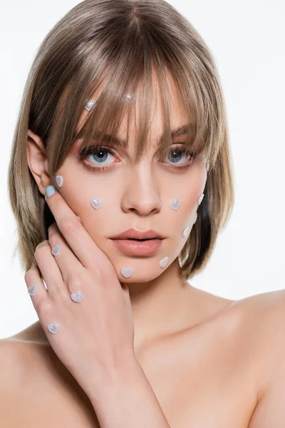 Sensual mujer joven con elementos de forma de corazón nacreo en el maquillaje aislado en blanco - foto de stock