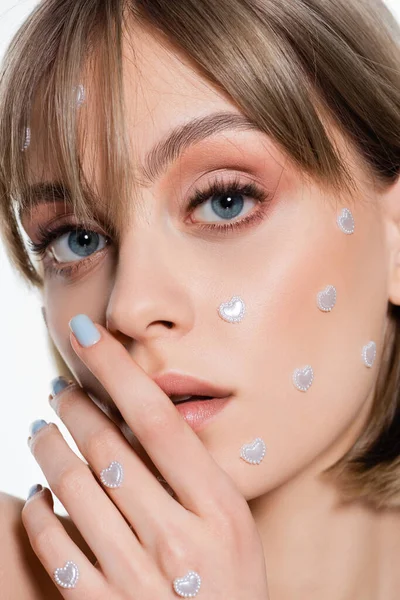 Close up de jovem mulher com elementos criativos de forma de coração na maquiagem isolada no branco — Fotografia de Stock