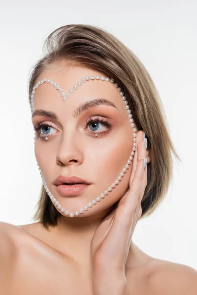 Jeune femme avec des perles créatives en forme de coeur sur le visage isolé sur blanc — Photo de stock