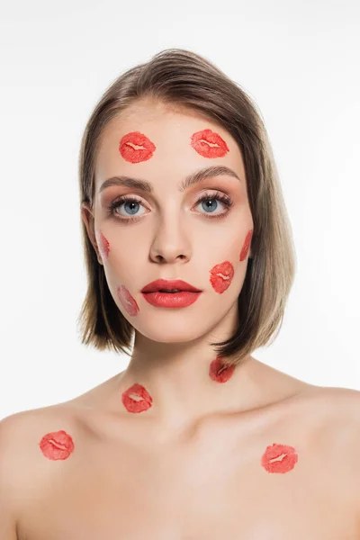 Red kiss prints on cheeks and body of young woman isolated on white — Stockfoto