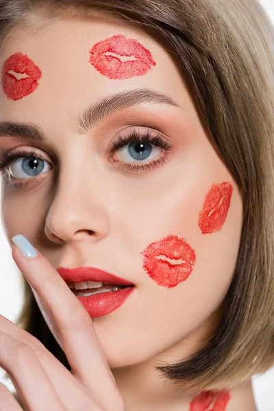 Close-up de jovem com gravuras de beijo vermelho nas bochechas e corpo isolado no branco — Fotografia de Stock