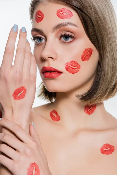 Red kiss print on hand of young woman isolated on white — Stock Photo