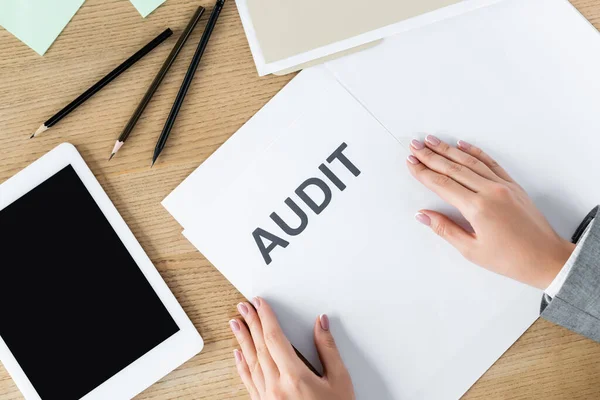 Vista superior de la mujer de negocios cerca del documento con letras de auditoría y tableta digital con pantalla en blanco - foto de stock