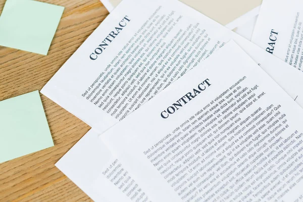 Top view of papers with contract near blank sticky notes on desk — Stock Photo