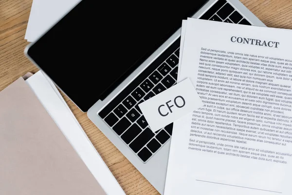 Top view of contract and paper cfo lettering on laptop keyboard — Stock Photo