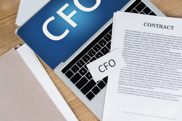 Top view of contract on laptop with cfo lettering on screen — Stock Photo