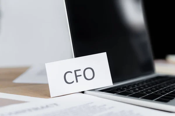 Primo piano di carta cfo lettering vicino computer portatile con schermo bianco — Foto stock