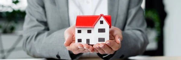 Cropped view of tax inspector holding house model in hands, banner — Stock Photo