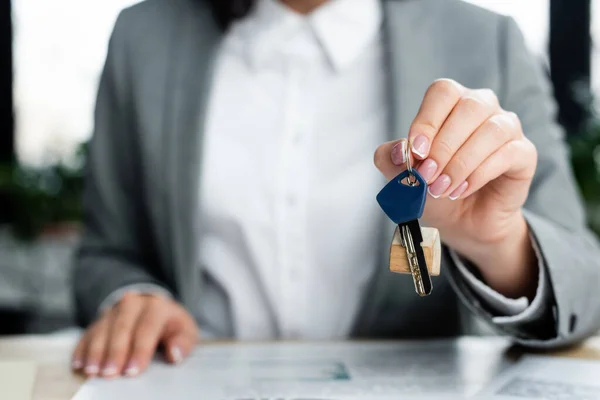 Vista recortada de la mujer de negocios sosteniendo la llave con llavero — Stock Photo