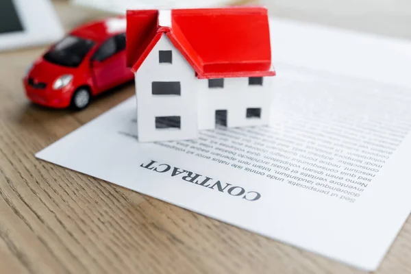 Модель дома и игрушечный автомобиль по контракту, концепция налоговой инспекции — стоковое фото