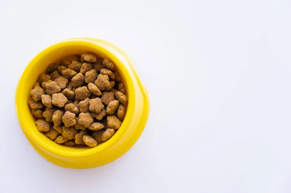 Vista superior de tigela de plástico amarelo com alimentos para animais de estimação isolados em branco — Fotografia de Stock