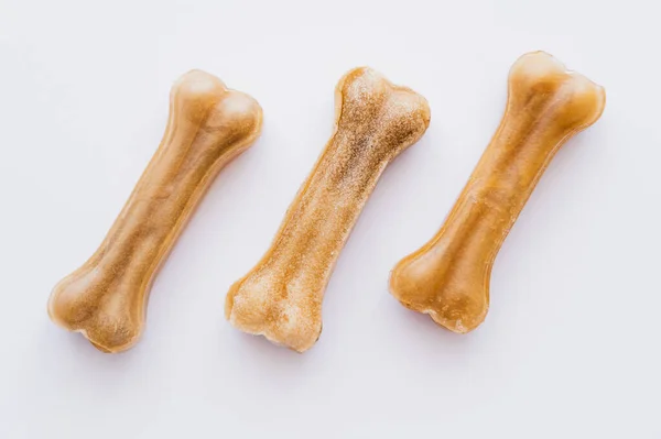 Disposición plana de las golosinas de mascotas en forma de hueso aislado en blanco - foto de stock