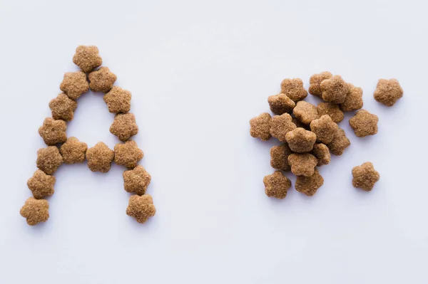 Vista superior de la carta cerca de alimento seco para mascotas aislado en blanco - foto de stock