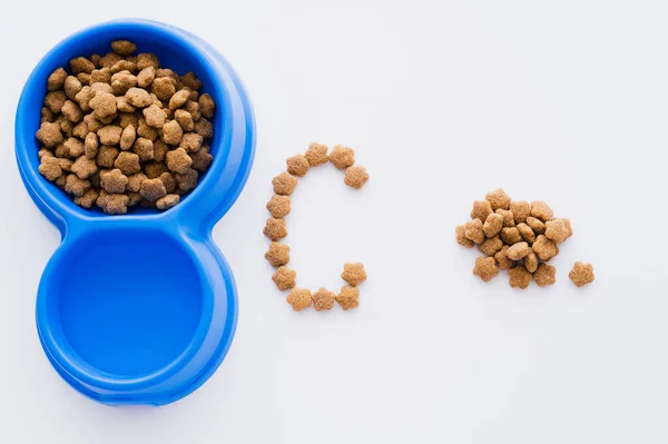 Vista dall'alto di lettera fatta di cibo per animali domestici e ciotole isolate su bianco — Foto stock