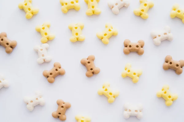 Vista superior de galletas en forma de hueso para mascotas aisladas en blanco - foto de stock