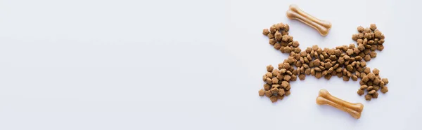 Vue du dessus des os et des aliments secs pour animaux isolés sur blanc, bannière — Photo de stock