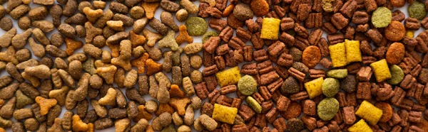 Top view of dry pet food in different shapes as background, banner — Stock Photo