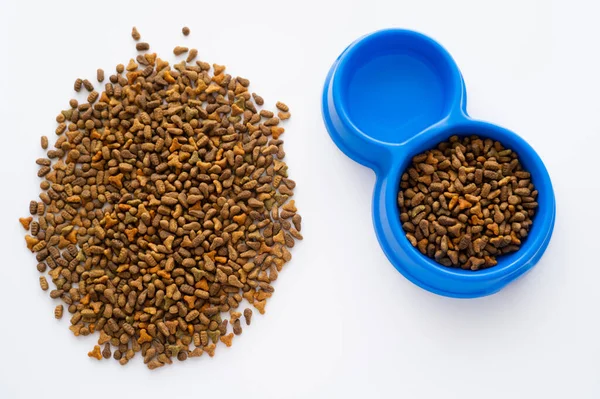 Top view of water in bowl with dry pet food isolated on white — Stock Photo