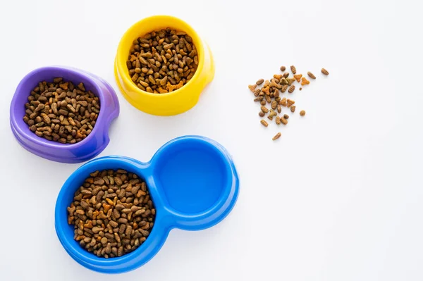 Top view of water near bowls with dry pet food isolated on white — Stock Photo