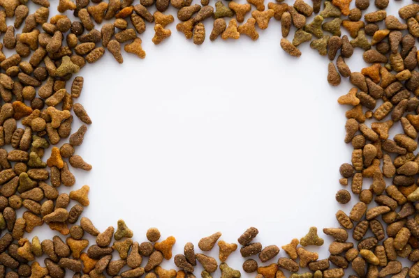Vista dall'alto di telaio in croccante cibo per animali domestici isolato su bianco — Foto stock