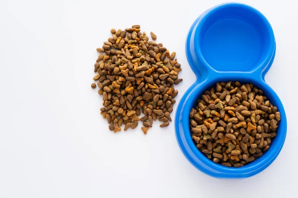 Top view of refreshing water in bowl with dry pet food isolated on white — Stock Photo