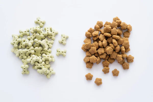 Vista superior de comida seca e guloseimas saborosas para animais de estimação isolados em branco — Fotografia de Stock