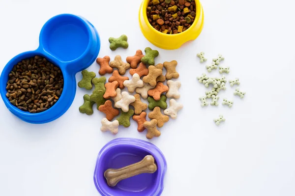 Vista dall'alto di gustosi biscotti a forma di osso vicino dolcetti e cibo per animali isolati su bianco — Foto stock