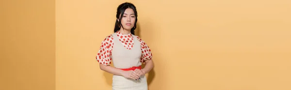 Modische asiatische Frau in Kleid und Bluse auf orangefarbenem Hintergrund, Banner — Stockfoto