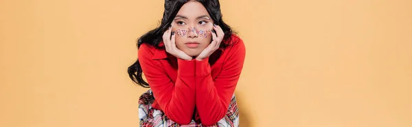 Giovane donna asiatica in glitter sul viso su sfondo arancione, banner — Foto stock