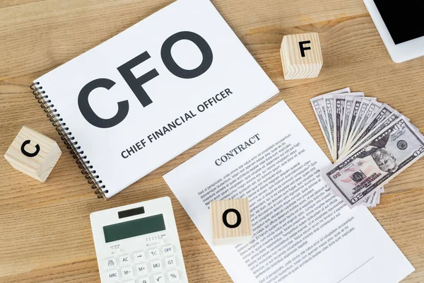 Notizbuch mit cfo-Schriftzug in Vertragsnähe, Geld und Taschenrechner auf dem Schreibtisch — Stockfoto