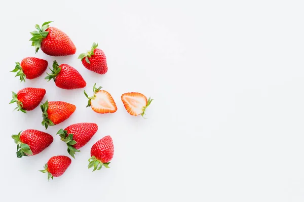 Draufsicht auf geschnittene und ganze Erdbeeren auf weißem Hintergrund — Stockfoto