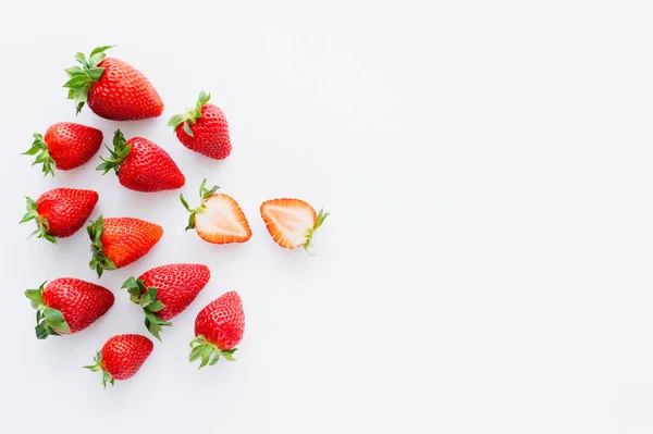 Vista superior de fresas cortadas y enteras sobre fondo blanco - foto de stock