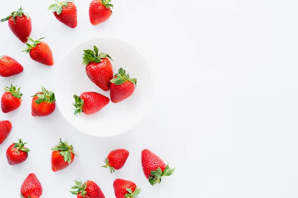 Vista superior de las sabrosas fresas en plato sobre fondo blanco - foto de stock