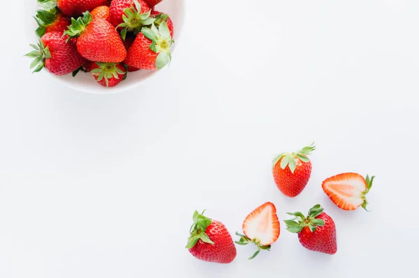 Draufsicht auf reife Erdbeeren mit Blättern auf weißem Hintergrund — Stockfoto