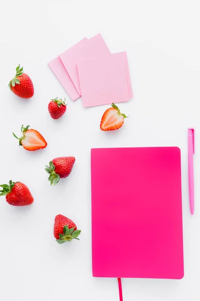 Top view of notebook near sticky notes and strawberries on white background — Stock Photo