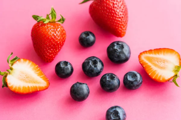 Close up view of sweet strawberries and blueberries on pink background — Stock Photo